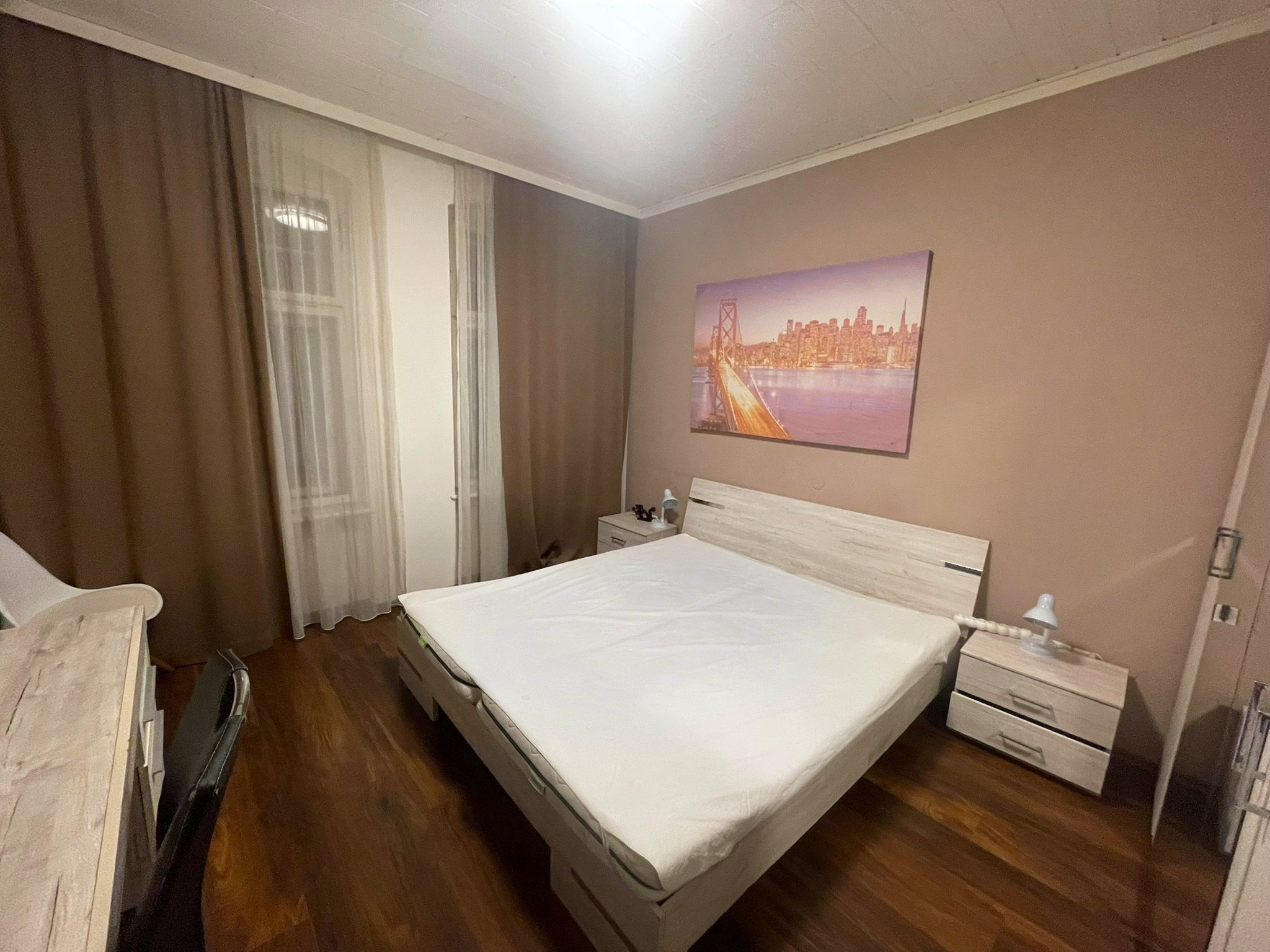 Doppelzimmer im Goldenen Kreuz mit hellem Doppelbett, zwei Nachtkästchen und großen Fenstern